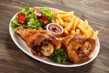 Grilled turkey legs with French fries and vegetables
