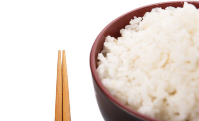 A bowl of rice and a pair of chopstick over white background