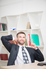 Businessman sitting at the table and working with laptop in offi