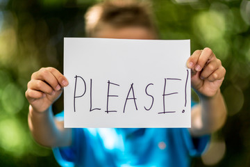 Boy with Please sign