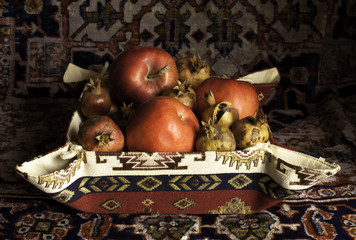 Still life of  pomegranate, apples and carpet