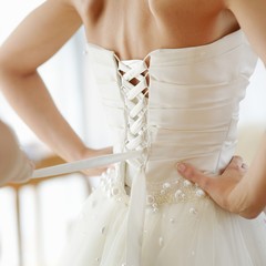 Helping the bride to put her wedding dress