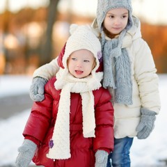 Two little sisters having fun on winter day