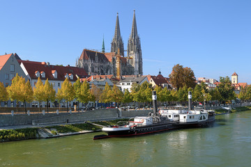 Fototapeta na wymiar Regensburg Cathedral and old steamship at the shore of Danube