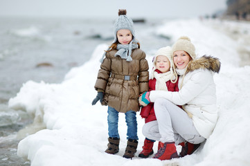 Mother and her daughters by the sea on winter