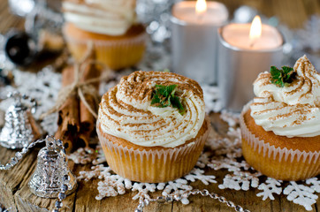 Christmas cupcakes with cream on a table decorated with Christma
