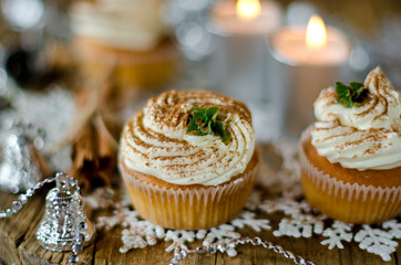 Christmas cupcakes with cream on a table decorated with Christma