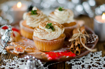 Christmas cupcakes with cream on a table decorated with Christma