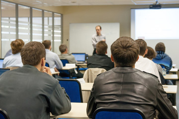 presenter near the screen and people sitting rear