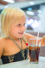 Adorable girl have meal with soda drink and fried potatoes at fa