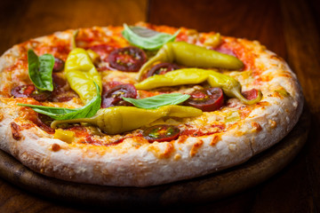 Homemade pizza with dried tomatoes and hot peppers