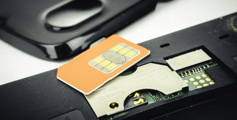 SIM card on black smart phone keypad