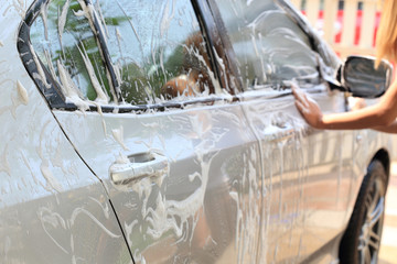woman hand hold sponge washing car