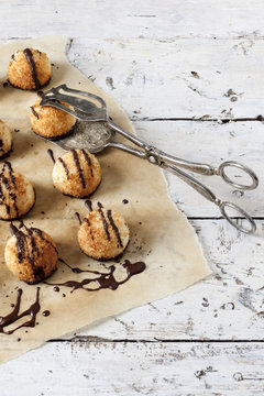 coconut macaroons with dripped chocolate on greaseproof paper