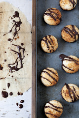 coconut macaroons with dripped chocolate on greaseproof paper