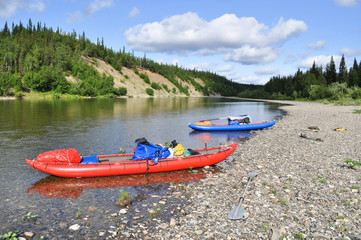 Fototapeta na wymiar Inflatable kayaks on the shore taiga rivers.