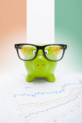Piggy bank with flag on background - Cote d'Ivoire