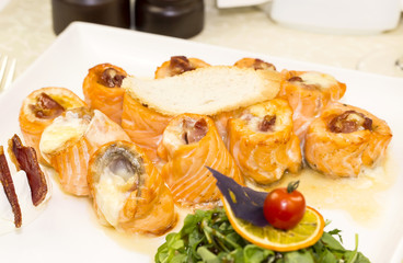 fried fish rolls with herbs on a white plate