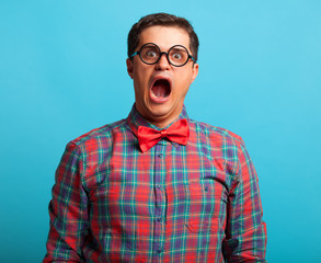 Nerdl man in shirt on blue background.