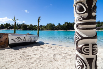 Small boat and totem on a Polynesian beach. Bora Bora