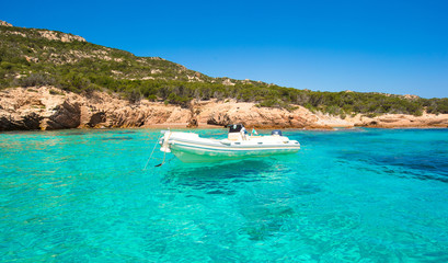 Fototapeta na wymiar Small boat in turquoise clear sea