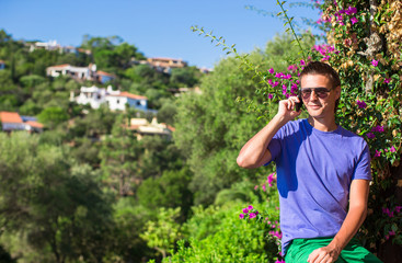 Young man talking on the phone at the balcony