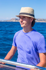 Fototapeta premium The young man at the helm of small boat