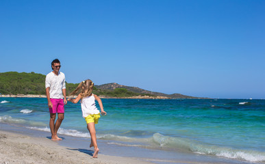 Young father and little daughter have fun during tropical beach