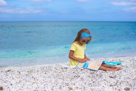 Adorable little girl with big map on tropical beach vacation