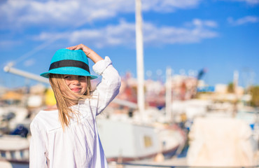 Adorable little girl have fun in a port on summer day