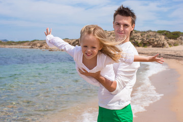 Happy father and cute little daughter have fun during beach