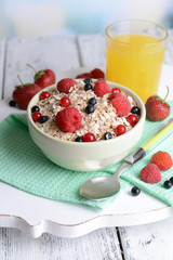 Tasty oatmeal with berries on table close-up