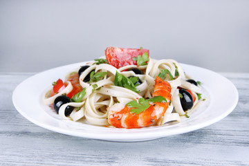 Fresh prawns with spaghetti, olives, tomatoes and parsley in a