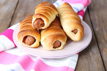 Baked sausage rolls on plate on table close-up