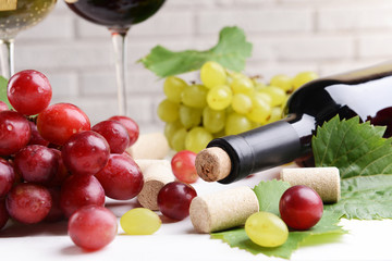 Wine bottle corks with grapes on table close-up