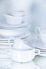 White crockery and kitchen utensils, on light background