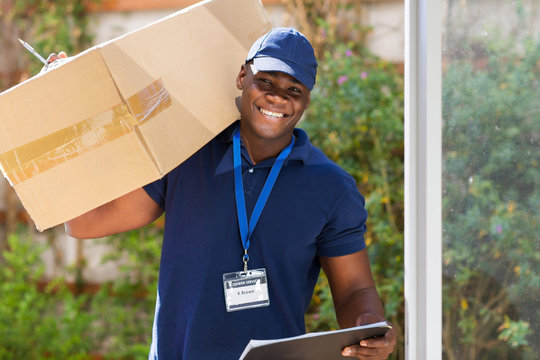 african courier standing with parcel at the door