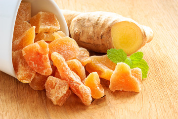Closeup root and candied ginger on wooden table