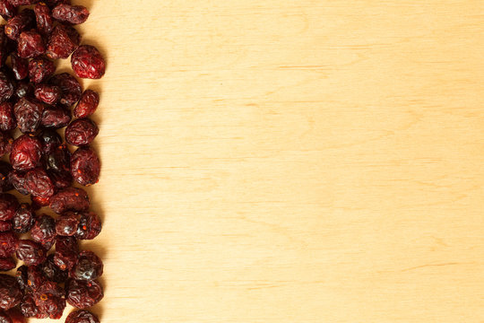 Border frame of dried cranberries on wooden background