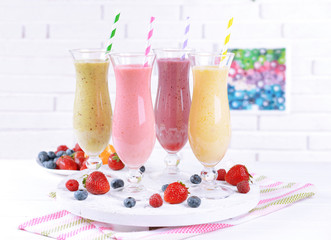 Delicious berry cocktails on table on brick wall background