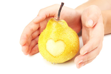 Ripe pear with heart in hands isolated on white © Africa Studio