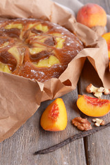 Delicious cake with peach and nuts on wooden table close up
