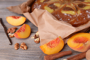 Delicious cake with peach and nuts on wooden table close up