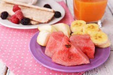Slices of fruits with crispbreads and glass of juice