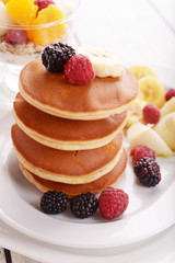 Pancake with fruits and muesli on plate on table close up