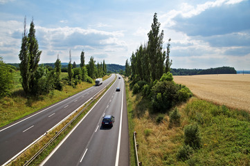 The rural landscape with a highway leading poplar alley