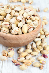full bowl of pistachio on wooden surface