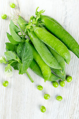 fresh pea pods on wooden surface