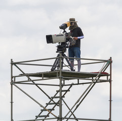Cameraman working on steel scaffolding.
