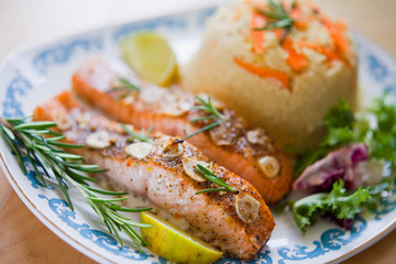 Roasted salmon fish with garlic fresh lettuce and couscous